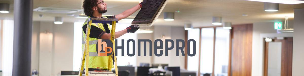 Trabajador de mantenimiento revisando el techo en una oficina moderna, subido en una escalera y utilizando equipo de seguridad. Logo de HomePro visible en primer plano.