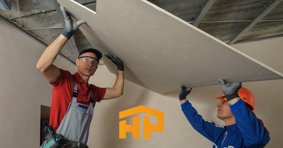 Dos trabajadores instalando un techo de tablaroca con precisión y herramientas profesionales. Renovación eficiente y de calidad con HomePro.
